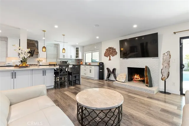 a living room with furniture a fireplace and kitchen view