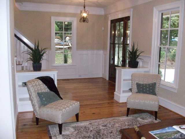 2630 Davis Street Raleigh, NC 27608 - Photo 3 of 12 Beautiful moldings and wainscotting greet you as you enter the foyer! Here you can see some of the built-in bookcases in the living room. Come over and see the built-in's that are floor to ceiling!