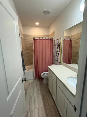 a bathroom with a sink a toilet a mirror and shower