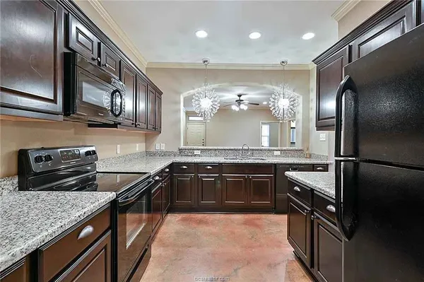 a kitchen with stainless steel appliances granite countertop a sink a stove and a refrigerator
