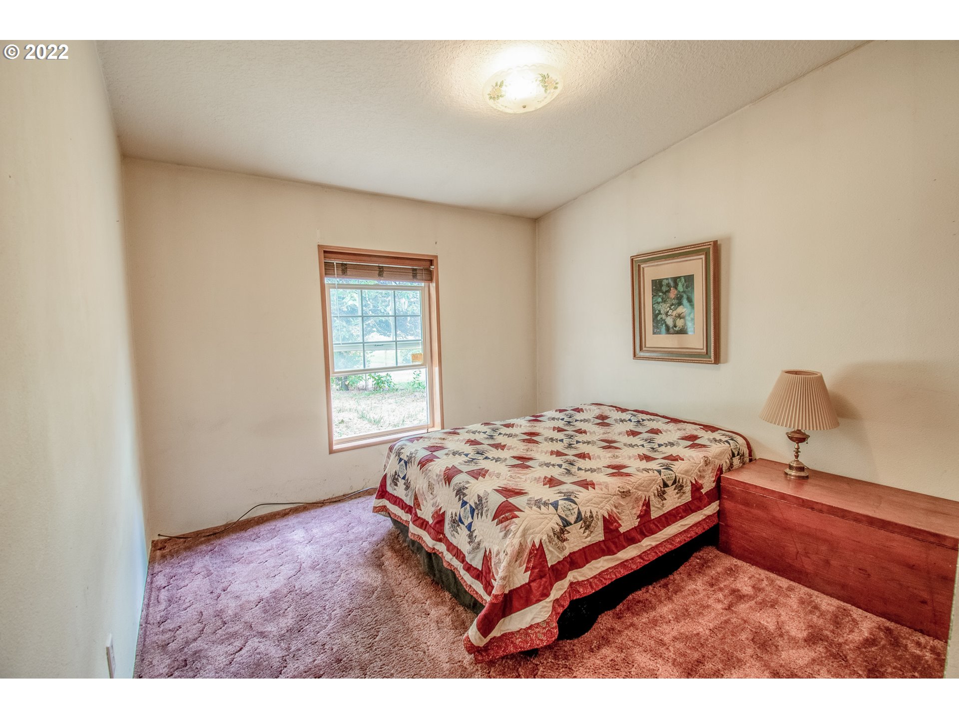 38435 Row River Road Dorena, OR 97434 - Photo 15 of 32 a bedroom with a bed lamp and a window