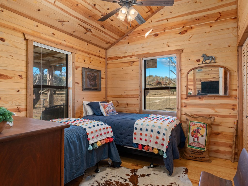 196 Hermit Hill Road Fredericksburg, TX 78624 - Photo 11 of 49 a bedroom with bed and wooden floor