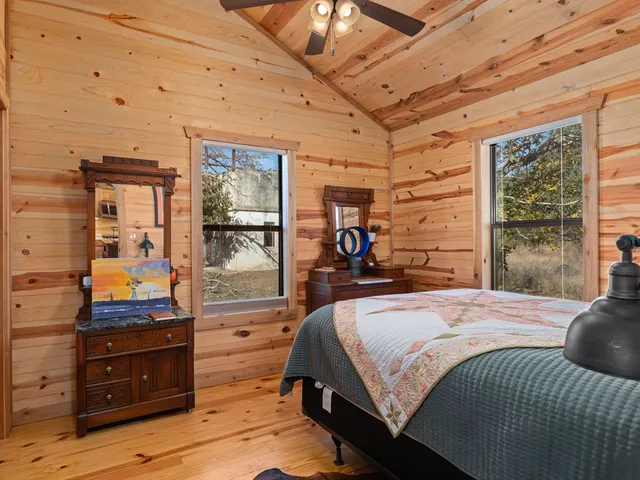 a bedroom with a bed and large windows