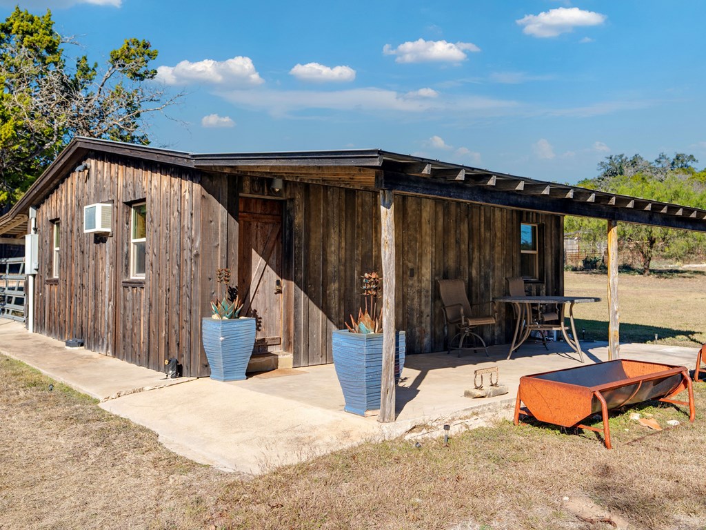 196 Hermit Hill Road Fredericksburg, TX 78624 - Photo 14 of 49 a wooden bench sitting in front of a building