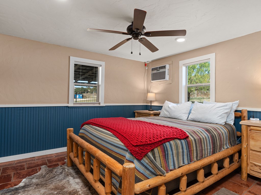 196 Hermit Hill Road Fredericksburg, TX 78624 - Photo 17 of 49 a bedroom with a bed and a chandelier