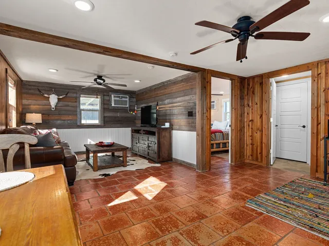 a living room with stainless steel appliances kitchen island granite countertop furniture a rug and a view of kitchen