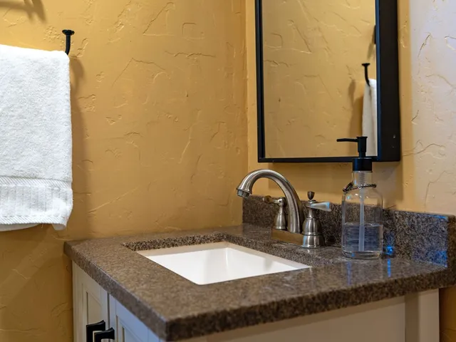 a bathroom with a granite countertop sink and a mirror