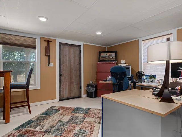 a view of a workspace with furniture and a window