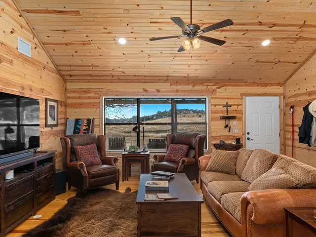 a living room with furniture a ceiling fan and a rug