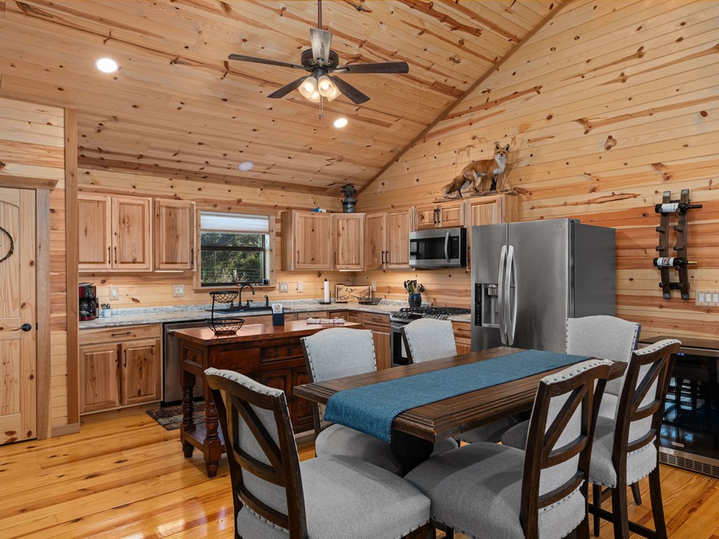 196 Hermit Hill Road Fredericksburg, TX 78624 - Photo 6 of 49 a kitchen with stainless steel appliances kitchen island granite countertop a table chairs and a refrigerator