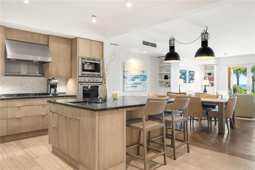 850 Beach Road, Unit 176 Indian River Shores, FL 32963 - Photo 3 of 18 a kitchen with stainless steel appliances kitchen island granite countertop a table and chairs in it