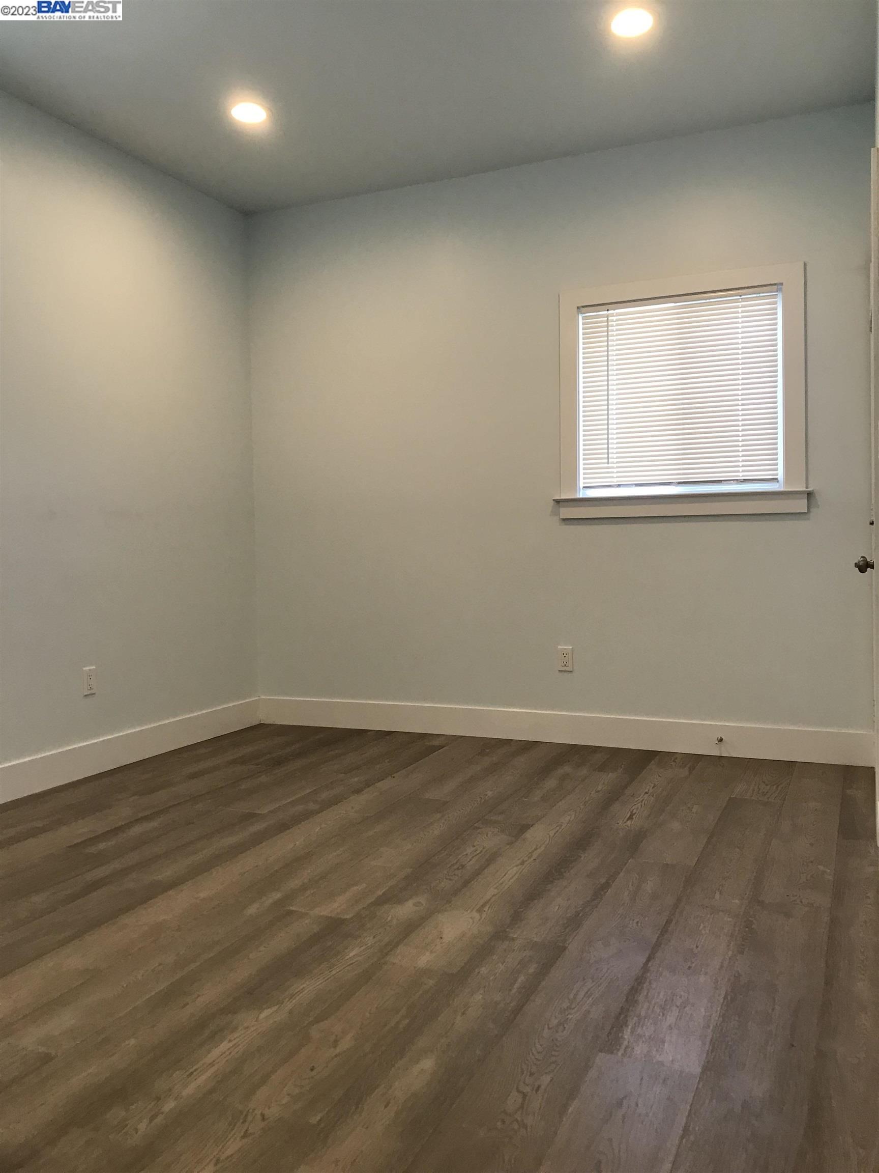Southwest Berkeley Berkeley, CA 94702 - Photo 4 of 6 a view of an empty room with wooden floor and a window