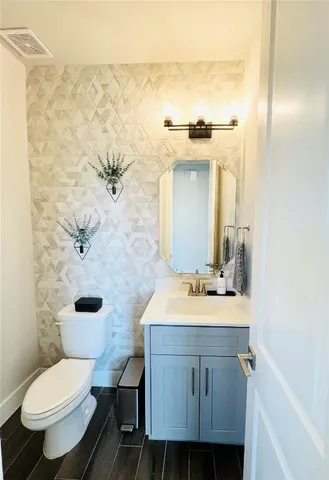 a bathroom with a sink toilet and mirror