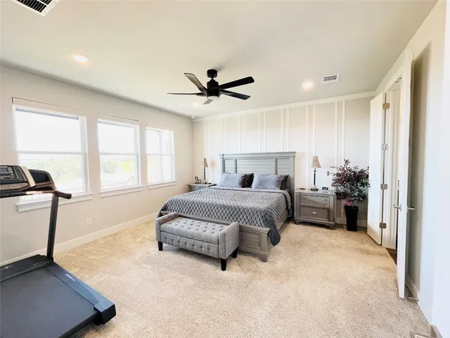 a spacious bedroom with a bed a window and a chandelier