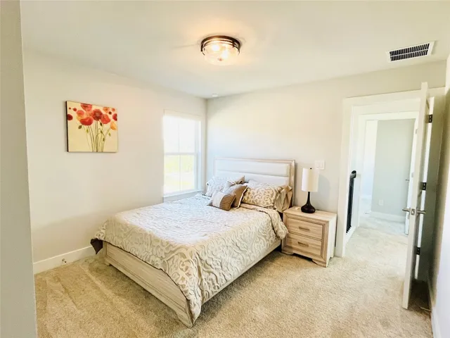 a bedroom with a bed and a painting on the wall