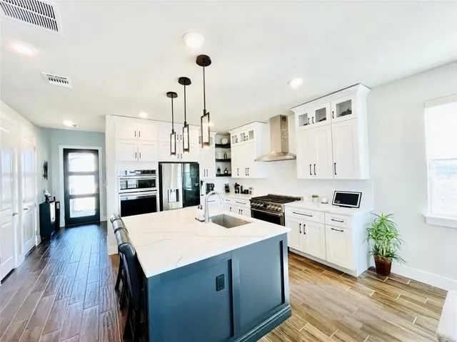 a kitchen with a stove a refrigerator and a stove top oven