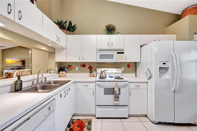 a kitchen with white cabinets and white appliances