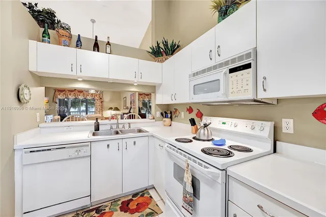 a kitchen with cabinets a sink and white appliances