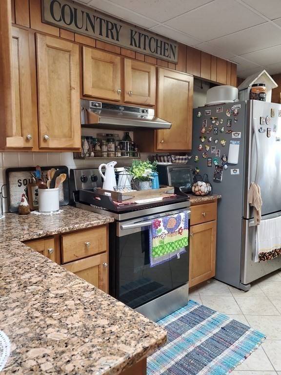 20 Baker Street Gardner, MA 01440 - Photo 4 of 15 a kitchen with stainless steel appliances granite countertop a stove and a refrigerator
