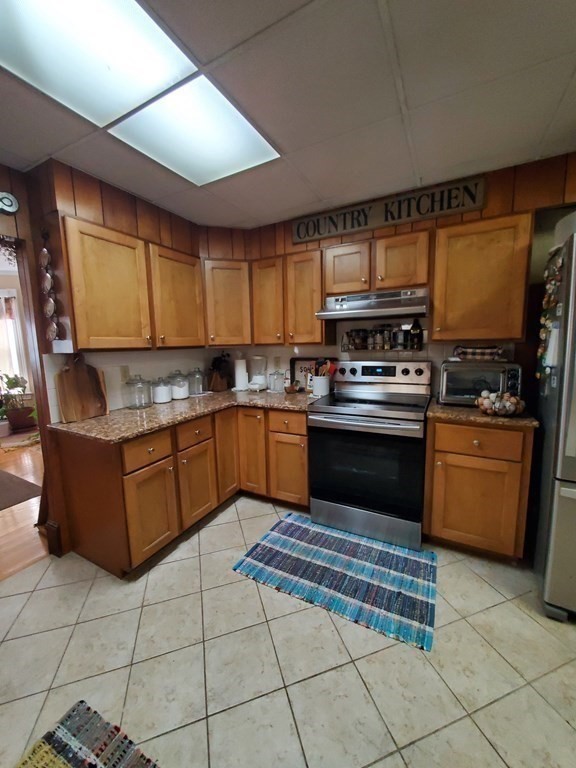 20 Baker Street Gardner, MA 01440 - Photo 8 of 15 a kitchen with granite countertop a stove top oven cabinets and a counter top space