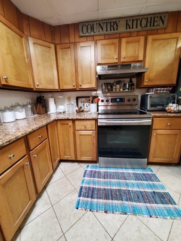 20 Baker Street Gardner, MA 01440 - Photo 9 of 15 a kitchen with stainless steel appliances granite countertop a stove a sink and a microwave