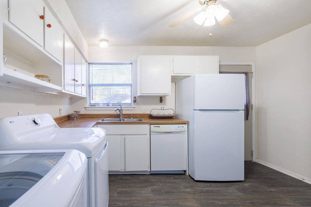 1723 Alhambra Street Dallas, TX 75217 - Photo 16 of 22 a kitchen with a sink a refrigerator and white cabinets