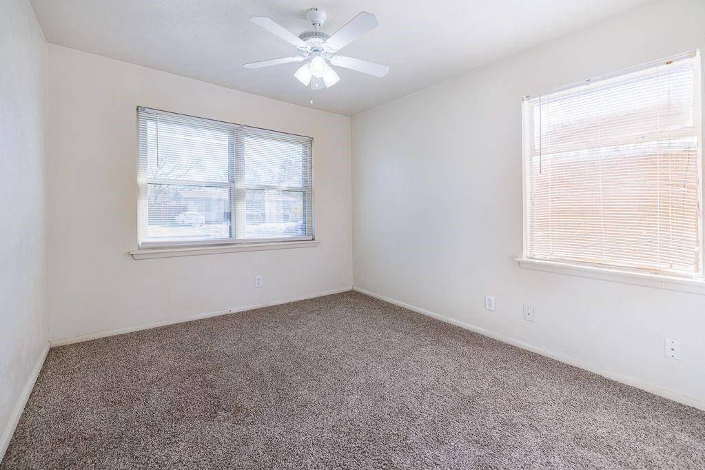 1723 Alhambra Street Dallas, TX 75217 - Photo 20 of 22 an empty room with a window and a fan