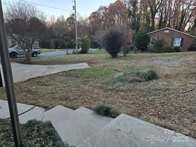 a view of a yard with wooden fence