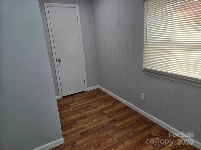 a view of a room with wooden floor and small window
