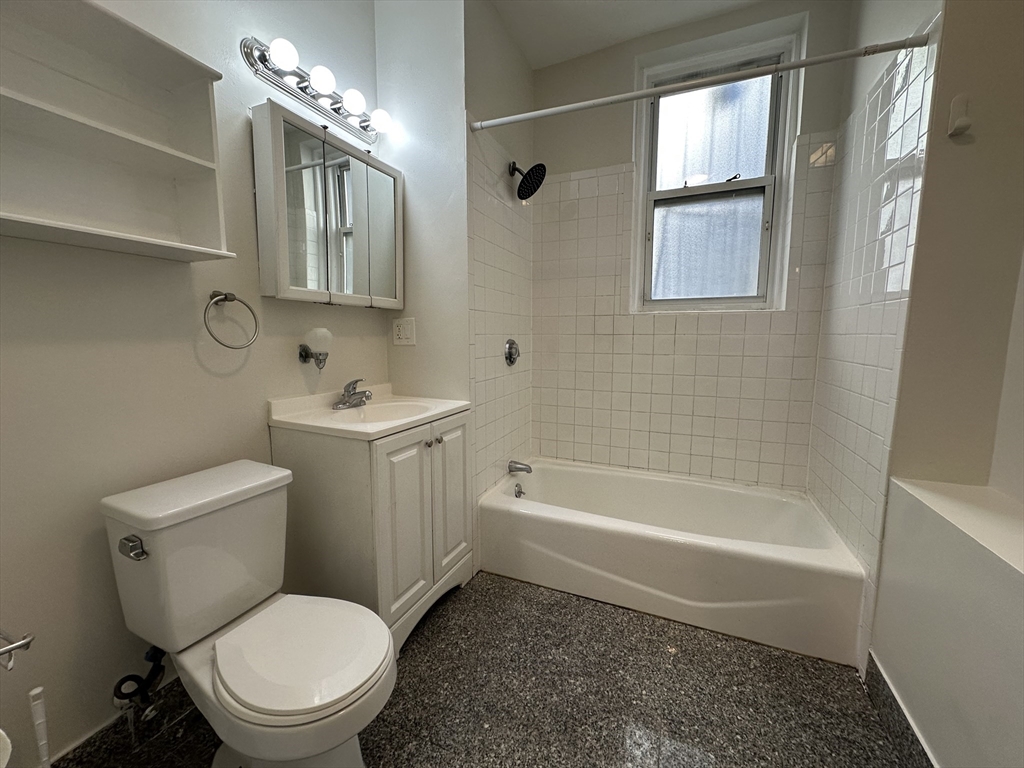 109 Strathmore Road, Unit B Boston, MA 02135 - Photo 4 of 9 a white toilet sitting next to a bath tub
