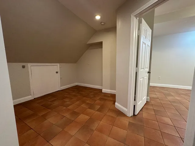 an empty room with white walls and tiles