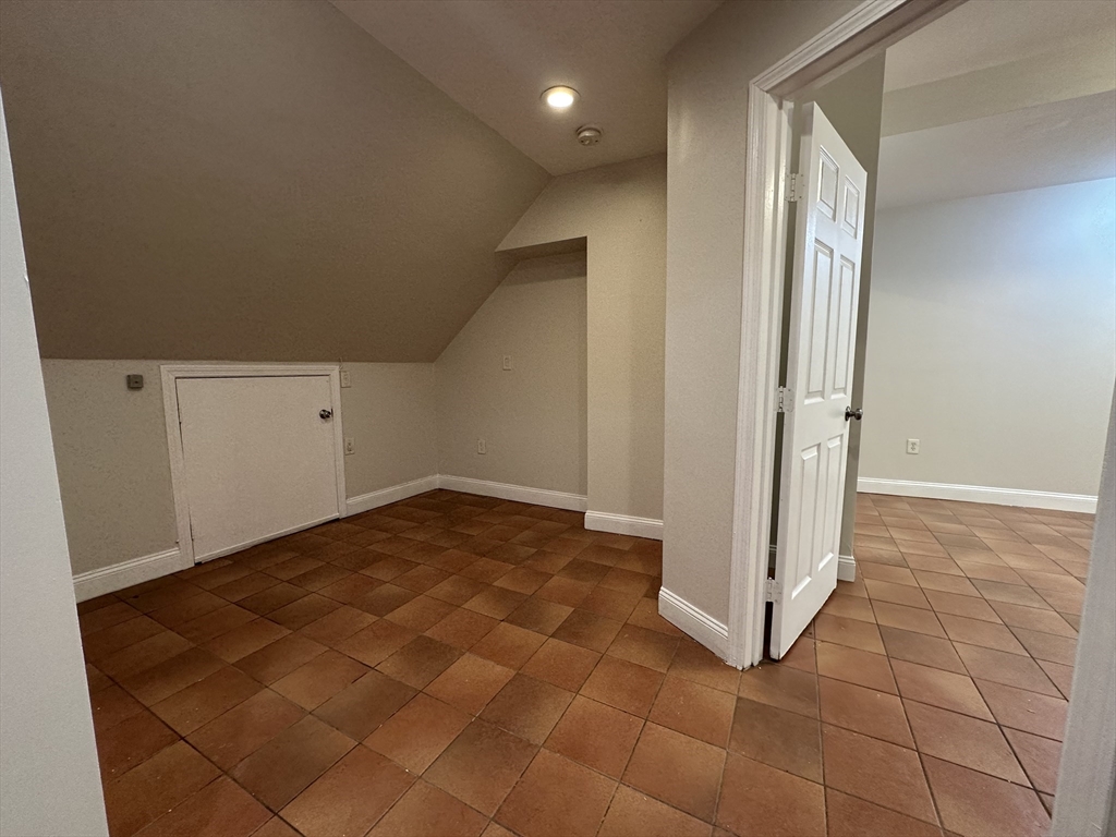 109 Strathmore Road, Unit B Boston, MA 02135 - Photo 7 of 9 an empty room with white walls and tiles