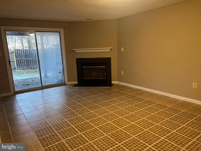 a view of empty room with wooden floor and fireplace