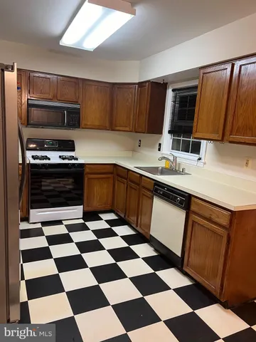 a kitchen with a sink a stove and cabinets