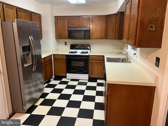 a kitchen with a refrigerator a microwave a sink and a counter top space