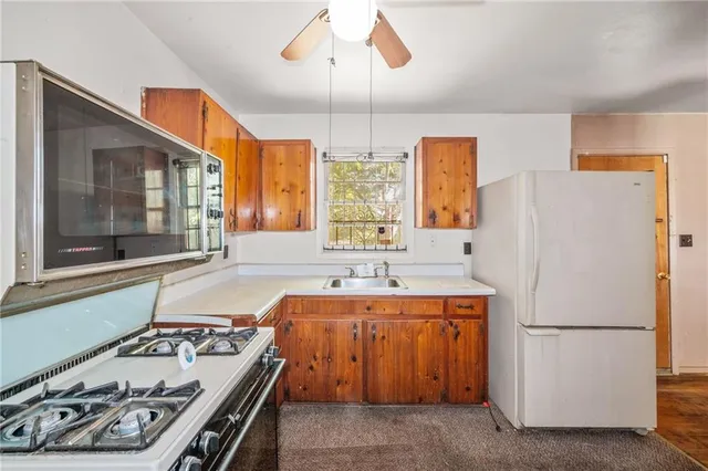 a kitchen with a stove a refrigerator and a sink