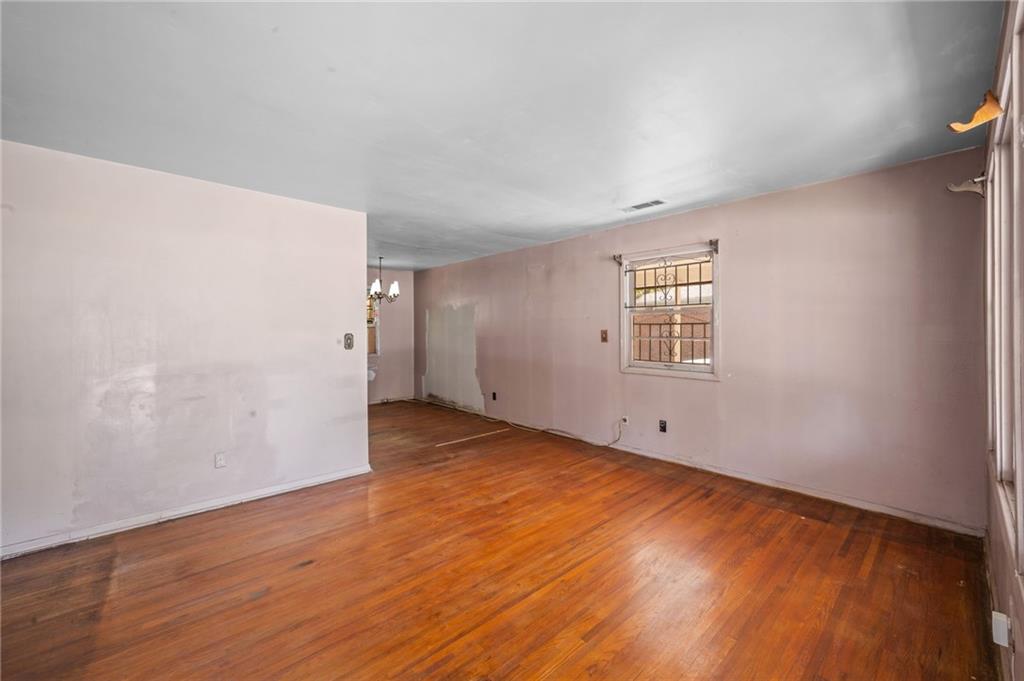 679 Bolton Road Northwest Atlanta, GA 30331 - Photo 3 of 30 an empty room with wooden floor and windows