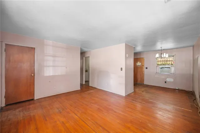 an empty room with windows and wooden door