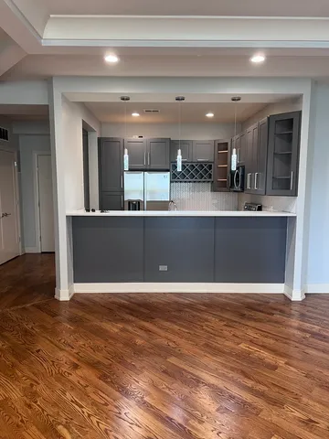 a kitchen with granite countertop a refrigerator and a stove top oven