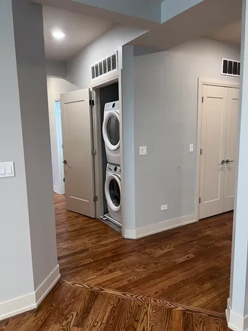 an empty room with wooden floor fireplace and windows