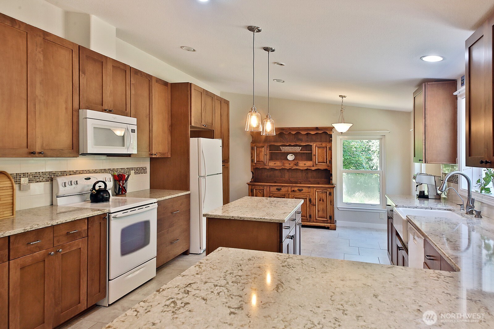 1677 Lancaster Road Freeland, WA 98249 - Photo 12 of 40 a kitchen with stainless steel appliances kitchen island granite countertop a refrigerator and a stove top oven