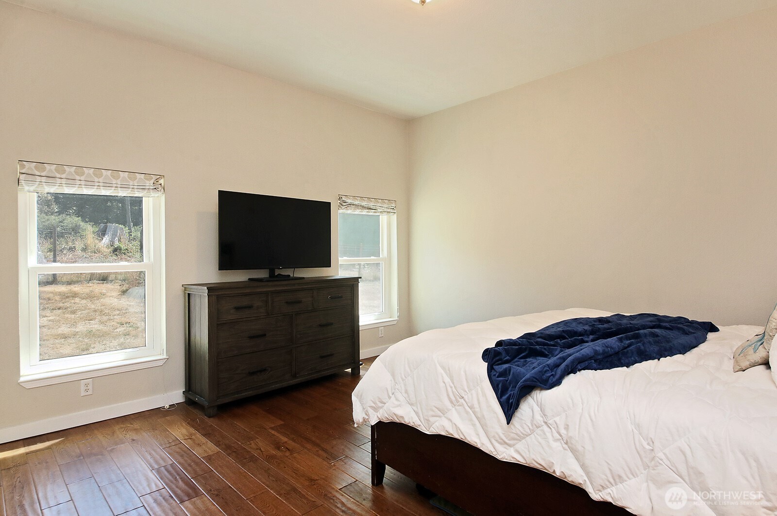 1677 Lancaster Road Freeland, WA 98249 - Photo 19 of 40 a bedroom with a bed and a flat screen tv
