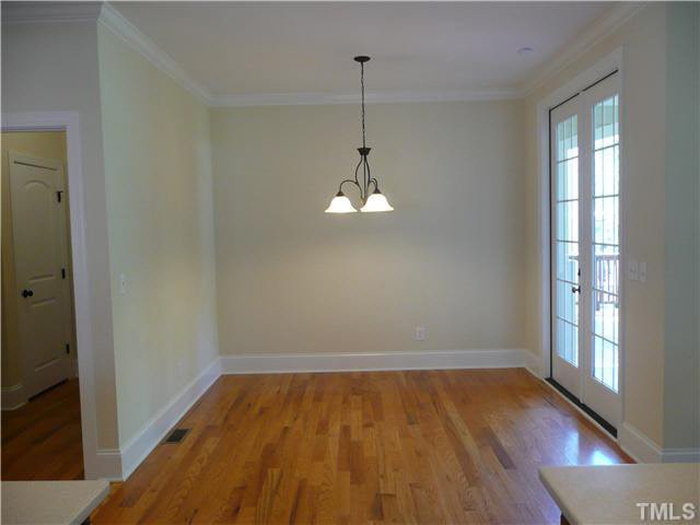 7333 Newport Avenue Raleigh, NC 27613 - Photo 8 of 20 a view of room with wooden floor chandelier and window