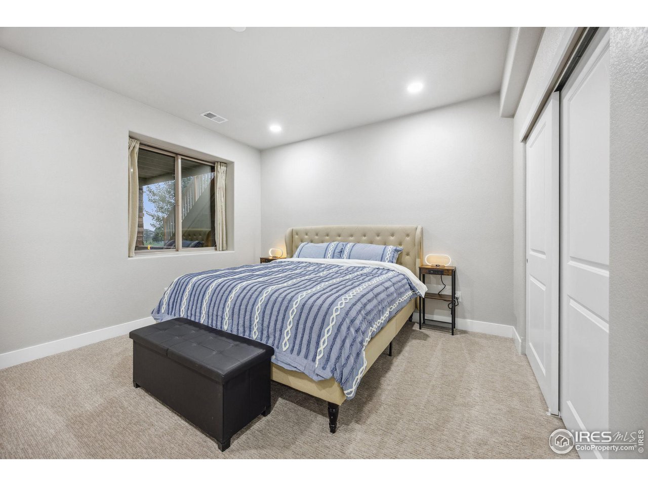 6178 Bay Meadows Drive Windsor, CO 80550 - Photo 30 of 40 a bedroom with a bed window and couch