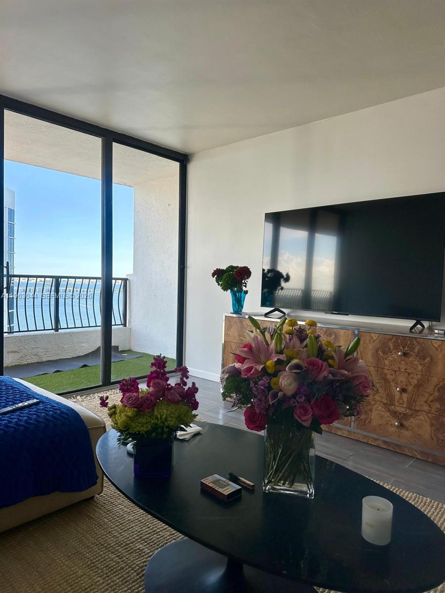 555 Northeast 15th Street, Unit 29G Miami, FL 33132 - Photo 5 of 11 a room with furniture and a flat screen tv