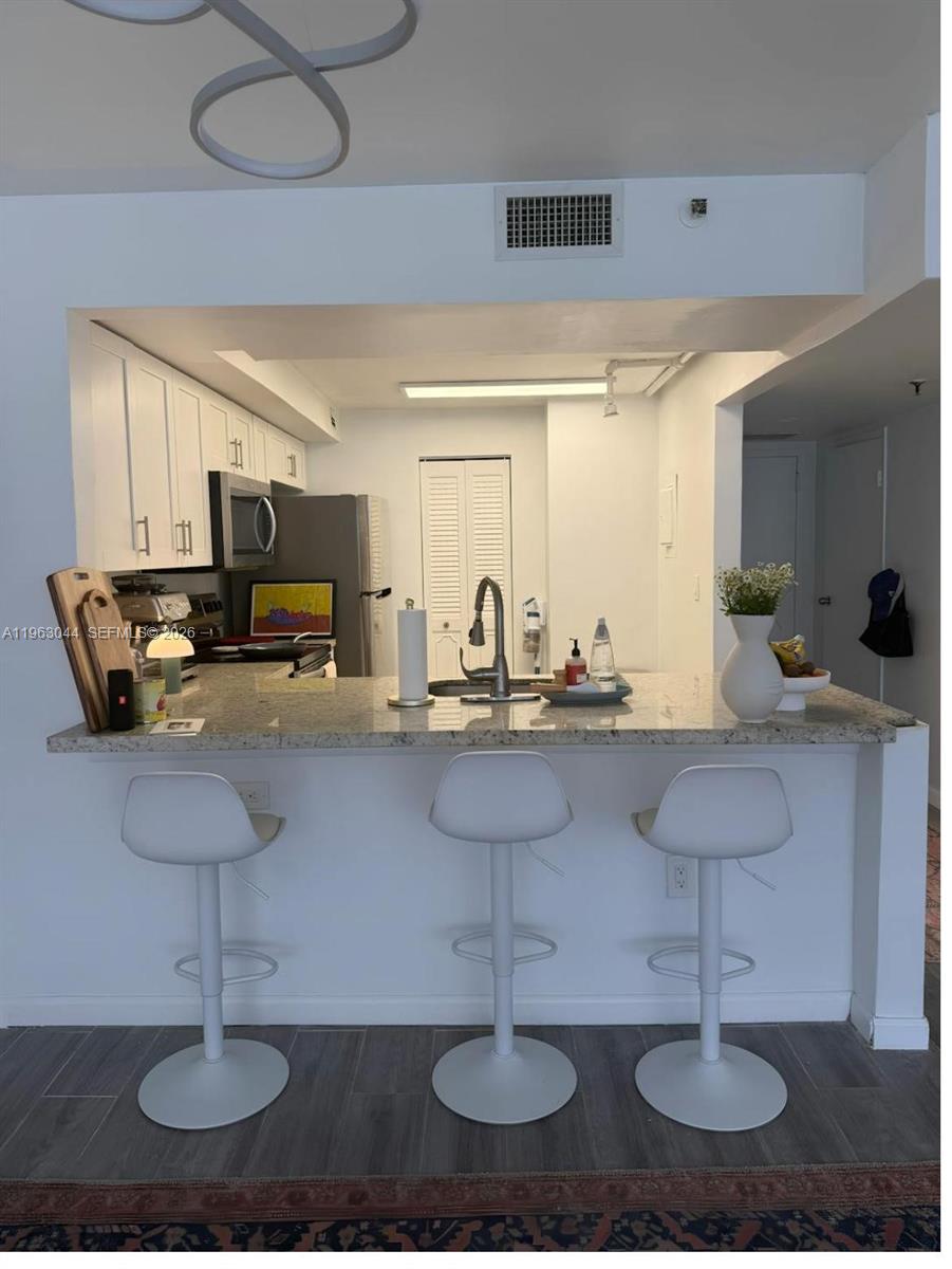 555 Northeast 15th Street, Unit 29G Miami, FL 33132 - Photo 7 of 11 a kitchen with counter space a sink and appliances