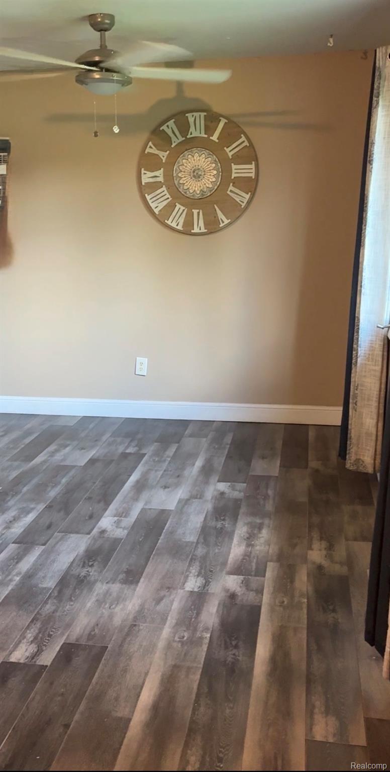 10340 Farrand Road Montrose, MI 48457 - Photo 15 of 31 AWood-finish flooring with varying tones, window with white trim, and a ceiling fan with integrated lightingdditional content