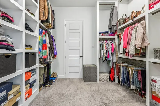 a view of walk in closet with clothes