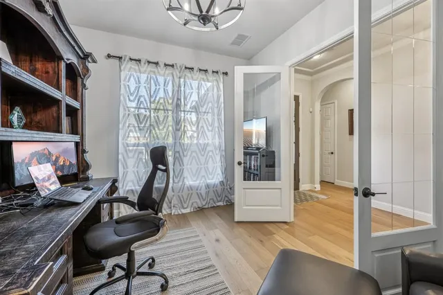 a room with lots of wooden furniture and a chandelier