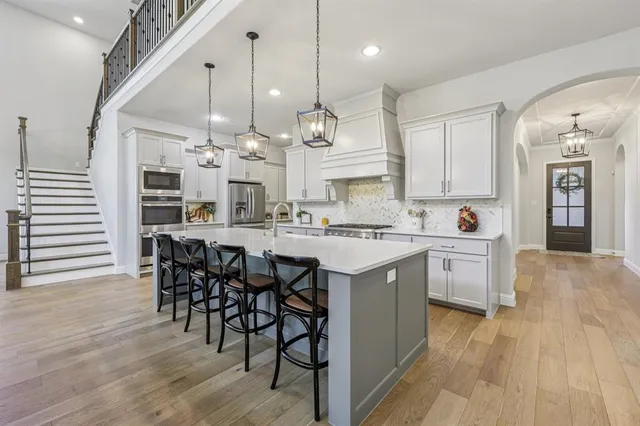 a kitchen with a dining table chairs stainless steel appliances and cabinets